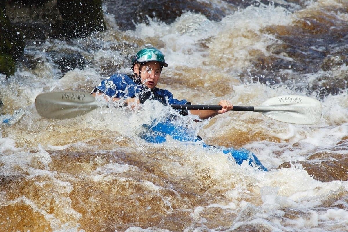 Kayaker navigating whitewater rapids - the thrill of learning river paddling